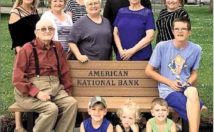 Shown in back row left to right is Jan Wilhelm Lions Club Trail Designer / Grant Writer, Rhonda Joy Bank Employee, Deb Lewis Bank President, Bev Simon lions Club Trail Secretary/ Treasure, James Jones Bank Employee, Nancy Crook Bank Employee, Megan Herr Bank Employee. Sitting on Bench is Ron Rist Lions Club President, Head of Trail and Lance Lewis. Sitting on the sidewalk in front is Megan Herrs’ children, Sutton, Corbin, and Jackson.