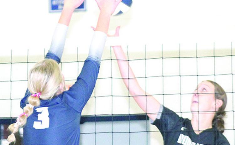HTRS’ Macy Vrtiska (#3, left) gets her hands on a block against the E-M-F Bobcats at the Pioneer. Paula Jasa/Republican