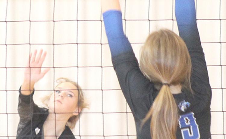 Paula Jasa/Republican P.C.’s Madison Fender (#5, left) launches a spike past a Nebraska City Lourdes defender in the Pioneer Conference 3rd place game on Saturday.
