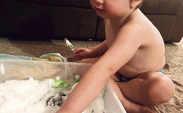 Charlie Neemann, 3, plays with his Hot Wheels in snow his mother, Michelle Wenzl, brought inside. These little cars are a lot easier to drive out of a snow drift.