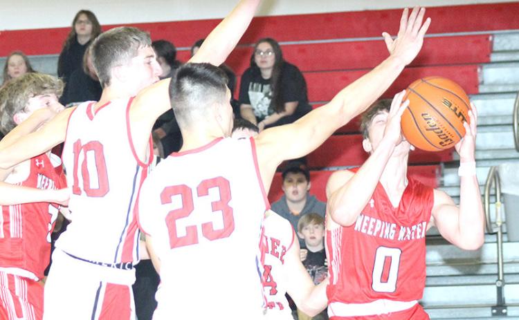 P.C.’s Drew Menninga (#20) and Anthony Kling (#23, left) prevent a Weeping Water player from driving the baseline in Tuesday night’s game before the Holiday break. Paula Jasa/Republican