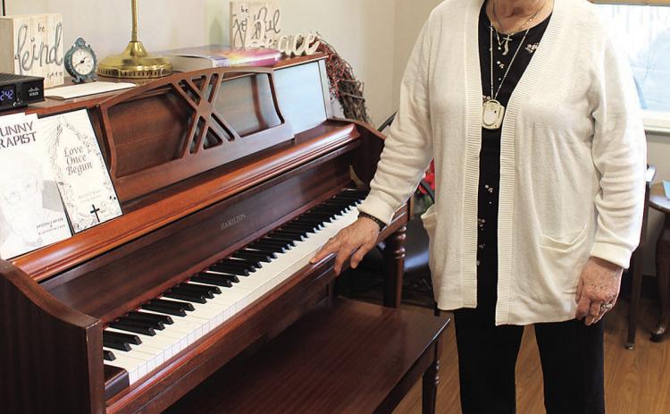 Shirley Huls stands by the piano in the Pawnee City Assisted Living Facility. Huls learned to play the piano as a little girl in the 30s and 40s and still enjoys listening to classical music as an adult.