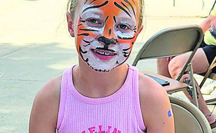 Madison Lewis enjoys the face paint provided by Taylor Porter