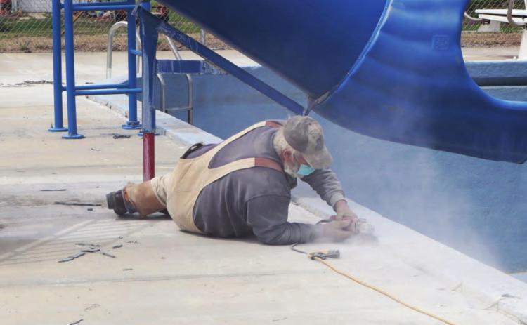 Steve Kreifels works at grinding off the cold joints at the pool. Ray Kappel/Republican