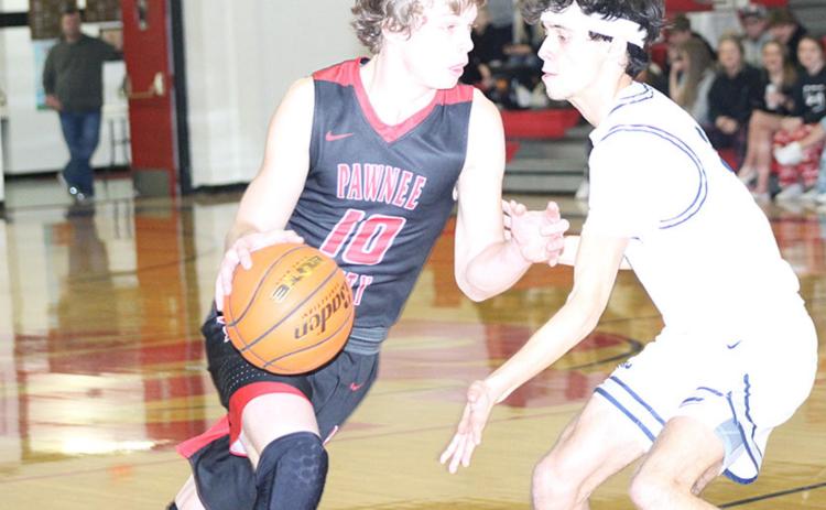 P.C.’s Kyle Gyhra (#10, left) drives against HTRS’ Nic Knudson (right) in Pioneer consolation action on Friday. Both players helped lead their teams in scoring. Paula Jasa/Republican