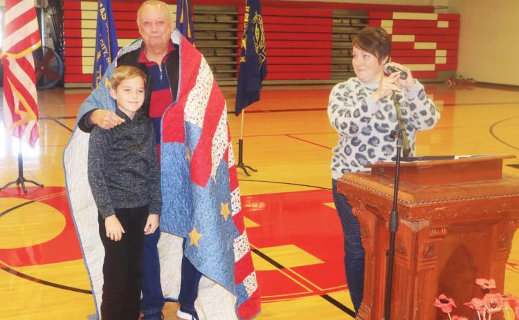Ray Kappel/Republican Veteran Larry Sinagoga with his grandson JJ Maynard and his mom, Beka at the Pawnee City Schools Veterans Day program. JJ made a Quilt of Valor for his grandpa.