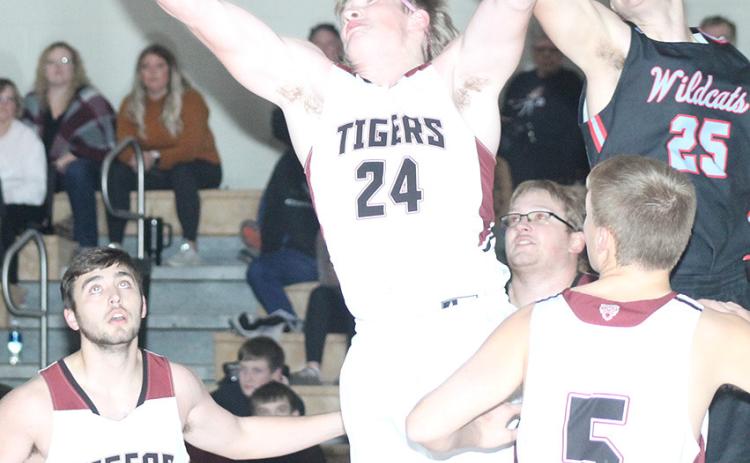 LHS’ Tristen Ray (#24, center) goes up for a rebound against Cedar Bluffs on Friday night while teammates Brady Bledsaw (#15, left); Everett Bohling (#5, right) look on. The Tigers won their third straight game of the week against Cedar Bluffs, 63-15. Paula Jasa/Republican