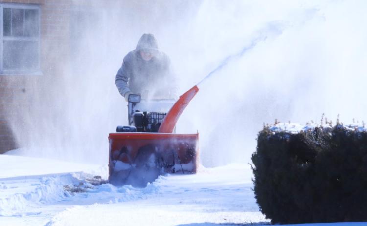 Keith Groeling clears the walks at Faith Baptist Church Sunday. Ray Kappel/Republican