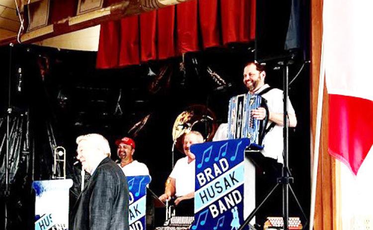 Joe Stehlik, the band’s sponsor, poses with them upon request