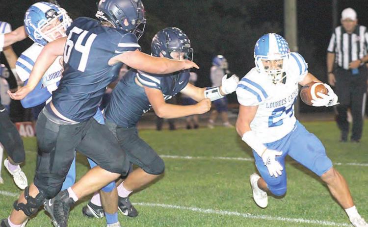 HTRS’ Andrew Stalder (#64, left) and Hunter Bohling (center, left) chase down a Lourdes Central Catholic ball-carrier in Thursday night’s final season game. Paula Jasa/Republican