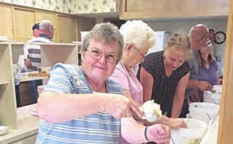Dipping up pineapple ice cream, Judy Bausch, who has attended Salem for 45 years. “I have made a lot ice cream!” she says.