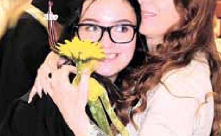 Graduating senior Rachael Ray hugs mom Heather Ray and gives her a sunflower, the class flower. Ray Kappel/Republican