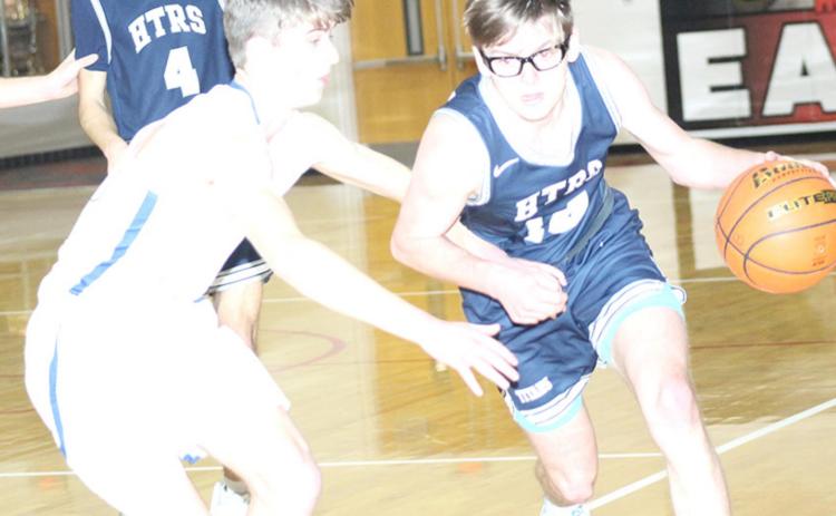 HTRS’ Gage Schaardt (#14, right) brings the ball down the floor against NCL in the Class D1-1 boys’ subdistrict finals on Thursday night. Schaardt hit six treys in the game and led the Titans with 20 points. Also pictured is teammate Nic Knudson (#4). Paula Jasa/Republican