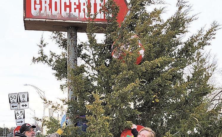 Jamie Kramer and Angie Hunt started to work on Christmas decorations at the Little Brown Jug in Pawnee City. They invite people to help decorate the huge tree they have set up under the sign for the Brown Jug.