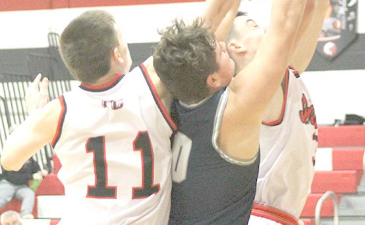 P.C.’s Brysen Horst (#11, left), HTRS’ Hunter Bohling (#0, center) and P.C.’s Jett Farwell (right) battle under the boards for a rebound at the Pioneer Tourney. Paula Jasa/Republican