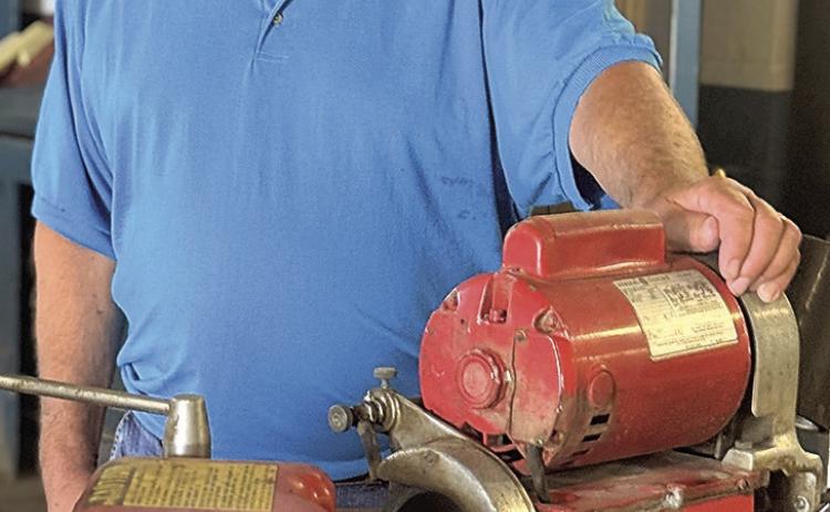 Randy Field with a valve grinder that has given faithful service. This item is on the auction and can be seen at the former Field Ford building in Tecumseh,