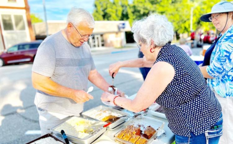 Arts Council board member Billie Kay Bodie of Burchard serves Larry Gilbert of Table Rock