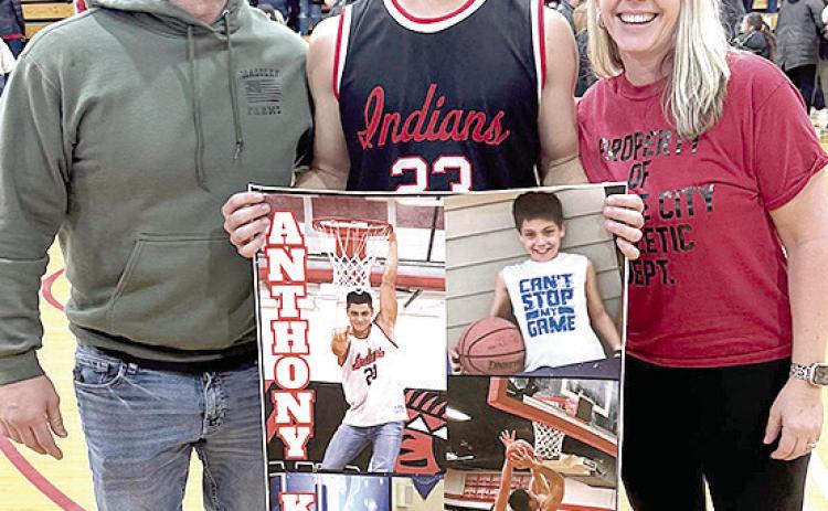 P.C.’s Anthony Kling (center) pictured with Shane and Jamie Maloley, proudly displays his poster of achieving 1,000 career points for the Pawnee City Indians after their game against Johnson-Brock last week. Photo provided